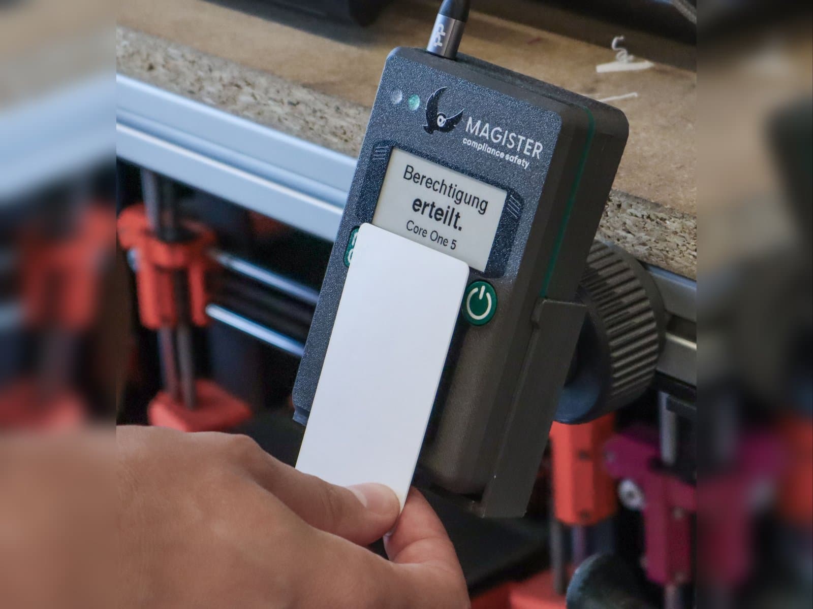 Nutzer hält NFC-Karte an den Magister Reader, Display zeigt Berechtigung erteilt